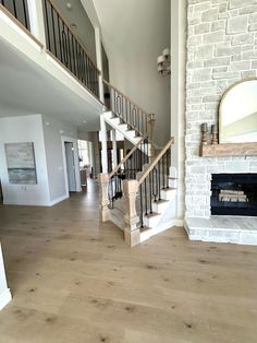 a living room filled with furniture and a fire place under a stair case next to a fireplace