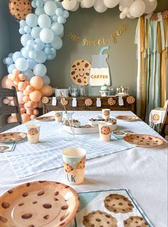 the dessert table is set up for a cookie themed birthday party with balloons and paper plates