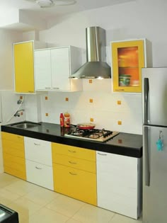 a kitchen with yellow and white cupboards and appliances