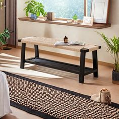 a living room with a couch, coffee table and potted plants