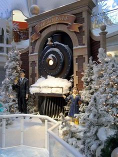 a train on display in front of christmas trees