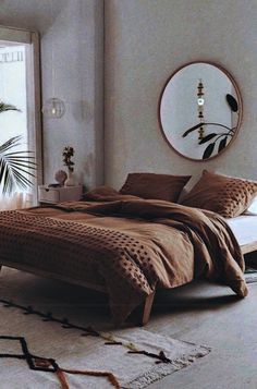 a bedroom with a bed, mirror and rug