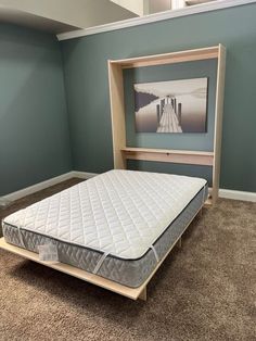 a bed with a built in bookcase on top of carpeted floor next to a window