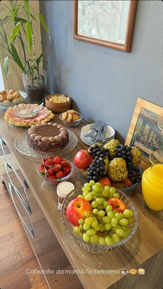 a wooden table topped with lots of different types of fruit and pastries on top of it