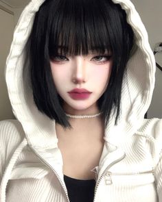 a doll with black hair wearing a white hoodie