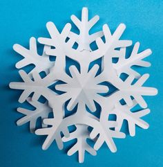 a snowflake made out of white paper on a blue background