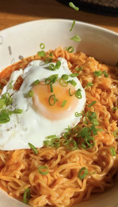 a bowl filled with noodles and an egg on top