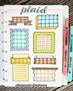 an open planner with plaid patterns on it and two pens next to it, sitting on a wooden table