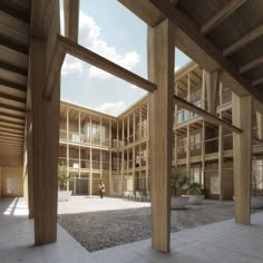 an empty courtyard with large wooden columns and planters on the ground in front of it