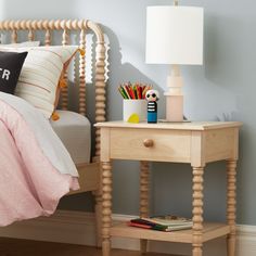 a bedroom with a bed, nightstand and colorful accessories on the night stand in front of it