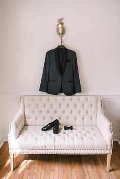 a suit and shoes on a white couch