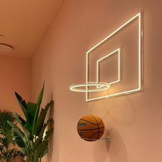 a basketball is on the wall next to a neon hoop