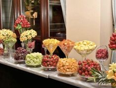 a buffet table filled with lots of different types of fruits and flowers on it's sides