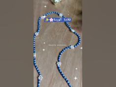 a blue and white beaded lanyard with stars on the side, attached to a wooden table