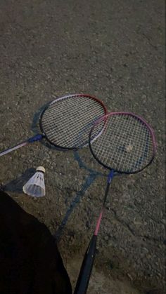 two tennis racquets laying on the ground next to each other with strings attached