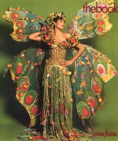 a woman in a costume made out of flowers and leaves with her hands on her hips