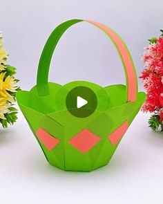 an origami basket with flowers in the background