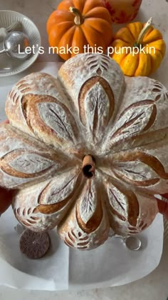 a loaf of bread sitting on top of a white plate next to some pumpkins