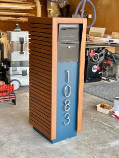 a wooden box with numbers on it in a garage area next to other boxes and tools