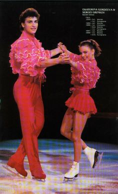 two people in red outfits are dancing on a stage with their arms around each other