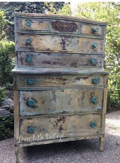 an old dresser with some paint on it's top and green knobs in the bottom