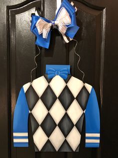 a door hanger with a blue and white argyle sweater on it's front