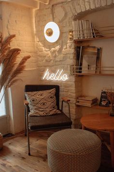 a living room filled with furniture and a neon sign on the wall above it that says hello