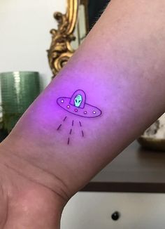 an alien tattoo on the wrist