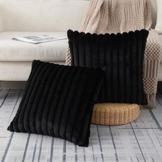 two black pillows sitting on top of a white couch