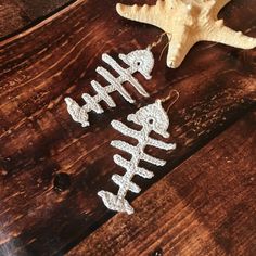 two christmas ornaments sitting on top of a wooden table next to a starfish ornament