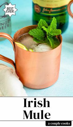 a copper mug filled with ice and mint sitting next to a bottle of irish mule