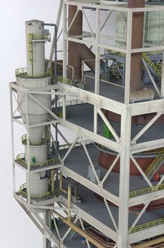 a model of a building with multiple levels and pipes on the top floor, in front of a white background