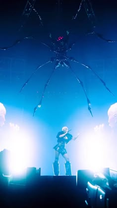 a man standing on top of a stage next to a giant spider