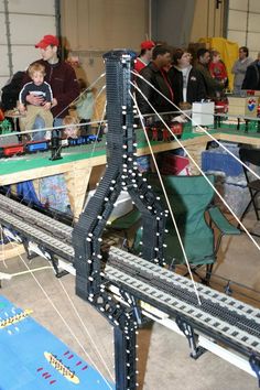 a group of people standing around a model train set