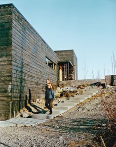 a woman is walking up the stairs to a building that has been built into it