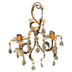 an antique chandelier with glass drops hanging from it's arms and leaves