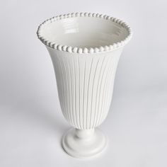 a white vase sitting on top of a table