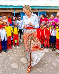 a woman is dancing in front of a group of children