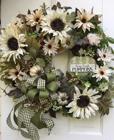 a wreath with sunflowers is hanging on the front door