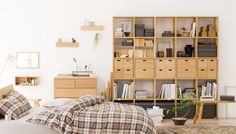 a bed sitting in a bedroom next to a wooden book shelf filled with lots of books