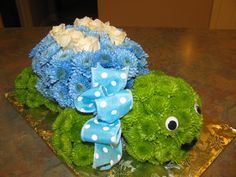 a bouquet of blue and green flowers sitting on top of a table