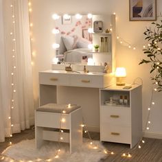 a white desk with lights on it and a mirror in the corner next to a potted plant