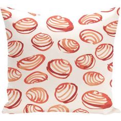 an orange and white pillow with red circles on the front, sitting on a white surface