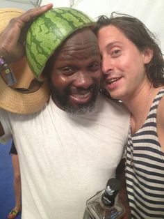 a man and woman posing for a photo with a watermelon on their head