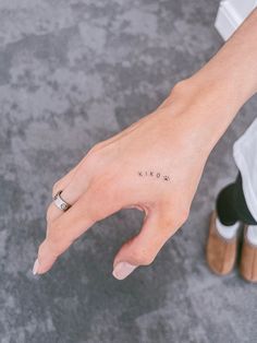 a person's hand with a small tattoo on it