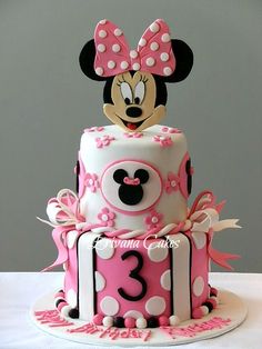 a minnie mouse cake with pink and white decorations