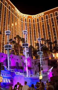 people are standing in front of the las vegas resort and casino at night with lights on