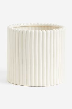 a white vase sitting on top of a table