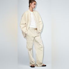 High-Waisted Pants With Side Pockets, False Back Flap Pockets, And Patch Pockets At Legs. Front Zip And Metal Hook Closure. Cream Cargo Pants For Workwear, Cream Cargo Pants With Pockets For Workwear, Cream Straight Leg Utility Pants, Zara Relaxed Fit Straight Cargo Pants, Zara Cargo Pants With Relaxed Fit, Beige Ankle-length Cargo Pants For Work, Beige Utility Parachute Pants For Fall, Spring Wide-leg Cargo Pants, Fall Utility Beige Parachute Pants