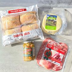 meat, cheese and other food items are laid out on the counter top in plastic bags